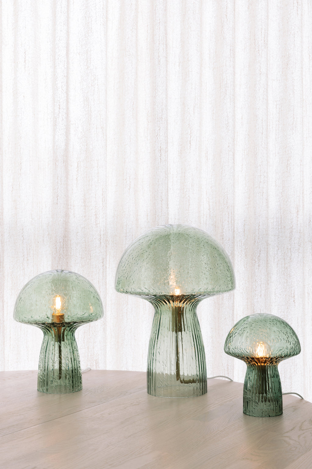 Lampe Fungo verte allumée dans un intérieur, Globen Lighting chez George Genève