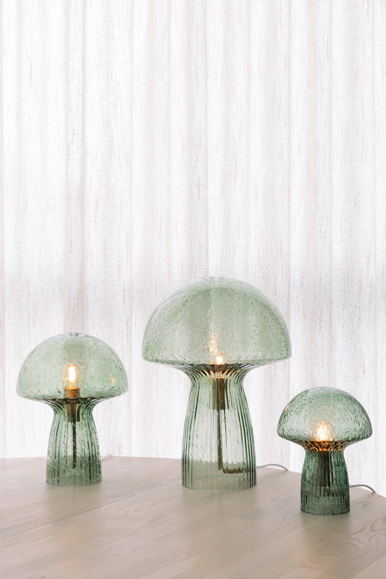 Lampe Fungo verte allumée dans un intérieur, Globen Lighting chez George Genève