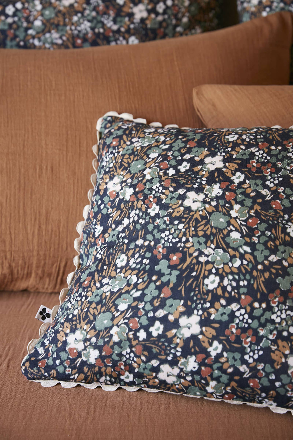 Coussin Capucine Minuit 40 x 40 cm en situation sur un canapé, L'effet Papillon chez George Genève