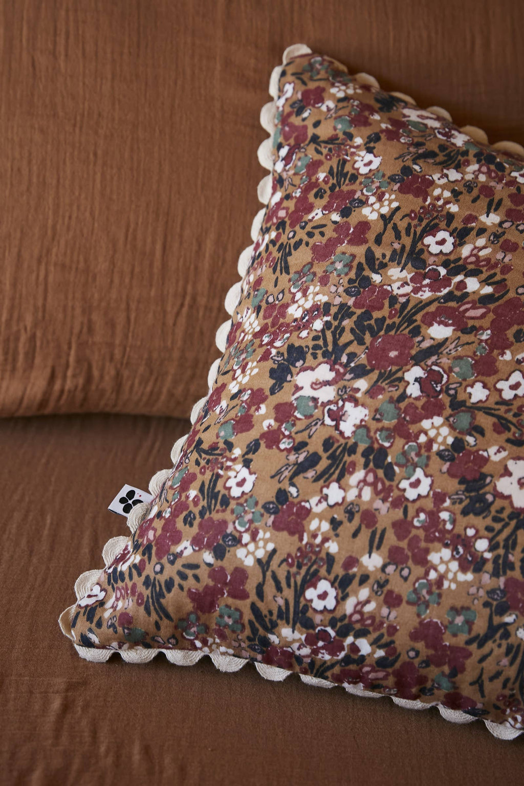 Coussin Capucine Camel 40 x 40 cm en situation sur un canapé, L'effet Papillon chez George Genève